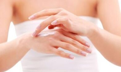 menina aplicando pomada na mão